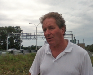 Protest organizer John Vitkevich in front of the toll gantry at the Sakonnet River Bridge. 