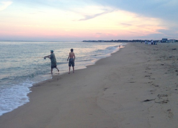 A father and son vacationing at East Beach go fishing at dusk, Aug. 2013. (Photo by Bob Plain) 