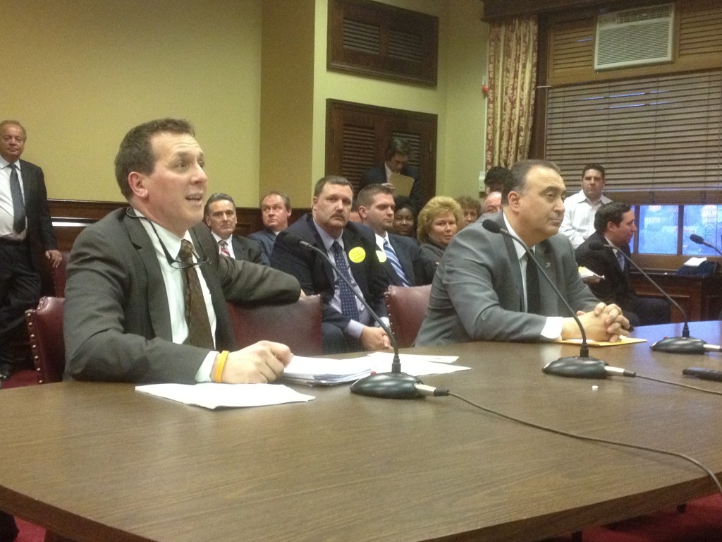 Rep. Frank Ferri testifies on his bill that would reform paypay loans in RI. In the background is Bill Murphy, former House speaker, a lobbyist opposed to the reform.