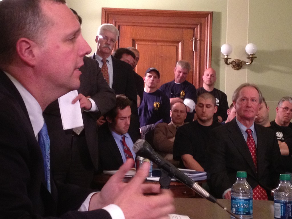 Chafee listens as Pawtucket Mayor Don Grebien speaks at the State House.